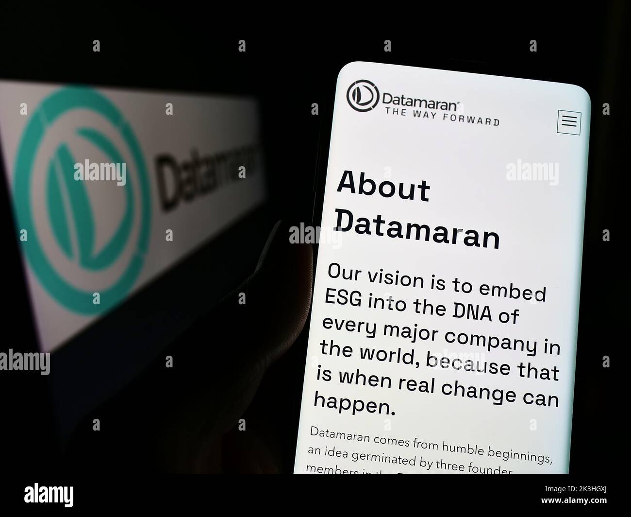 Person, die Mobiltelefon mit der Webseite des britischen Software-Unternehmens Datamaran Ltd. Auf dem Bildschirm vor dem Logo hält. Konzentrieren Sie sich auf die Mitte des Telefondisplays. Stockfoto