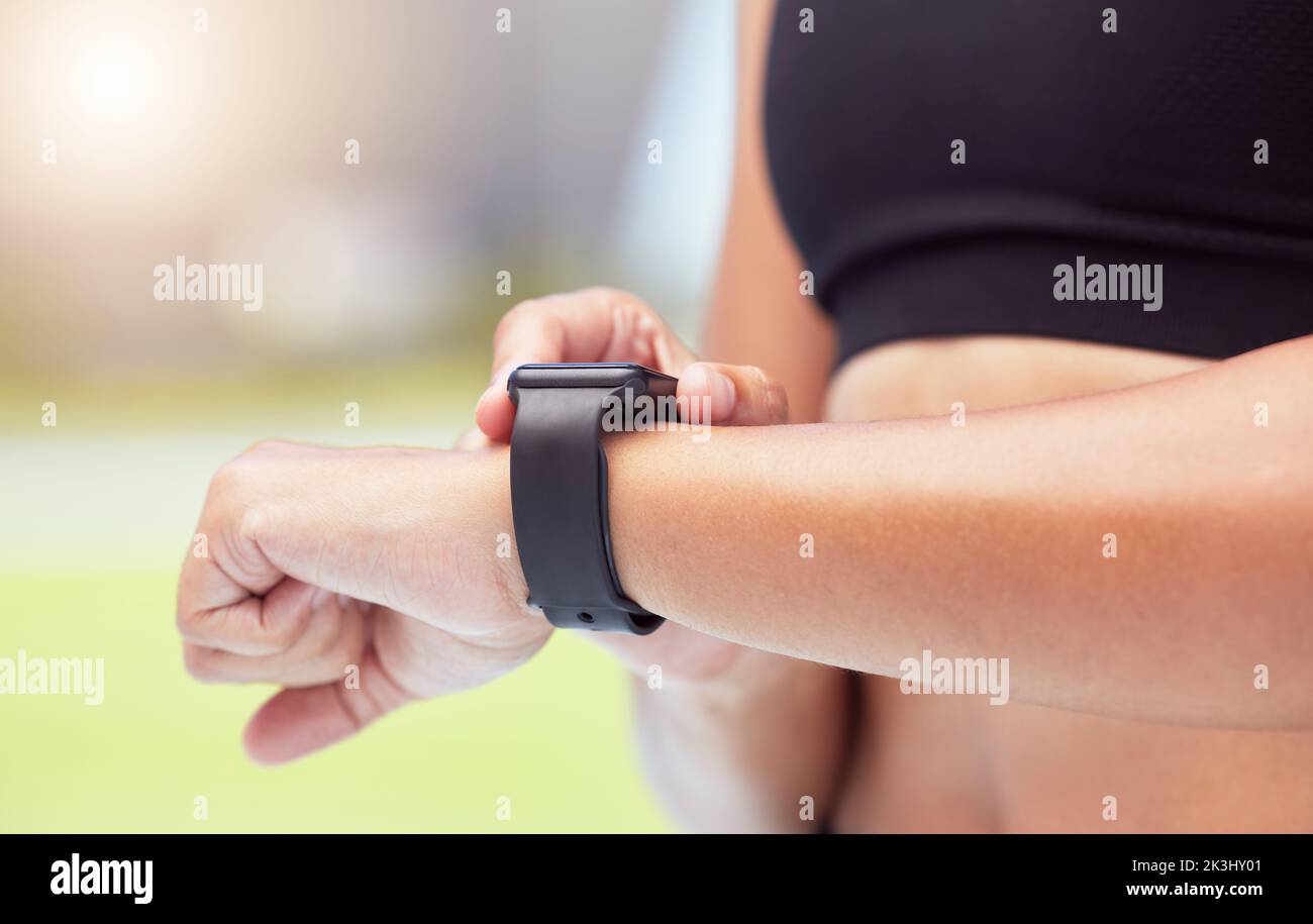 Smartwatch an den Händen der Läuferin, um die Laufzeit der Frau zu verfolgen, Gesundheitsstatistiken zu erfassen und für das Wettkampfrennen zu trainieren. Intelligente Uhren sorgen für konkurrenzfähige Leistung Stockfoto