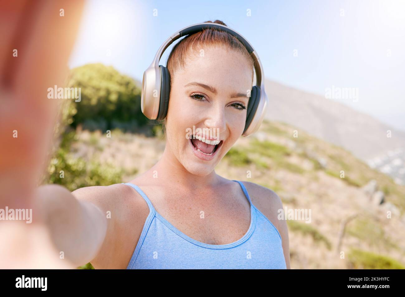 Fitness Selfie, glücklich und Lächeln der Frau Streaming Musik auf Kopfhörer im Freien in der Natur. Das Glück des Menschen nach dem Wohlbefinden, dem Sport und der Bewegung Stockfoto