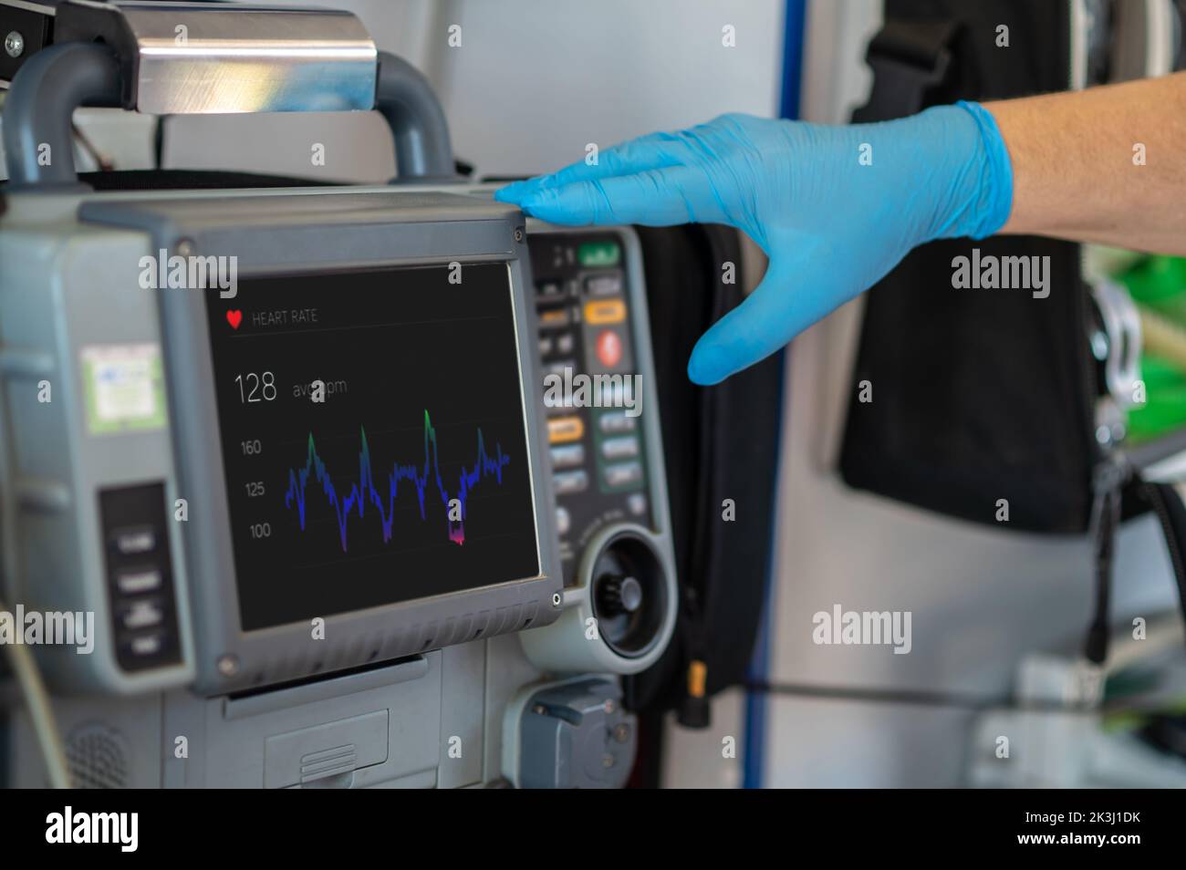 Der Sanitäter überwacht die Herzfrequenz des Patienten mit den medizinischen Geräten Stockfoto