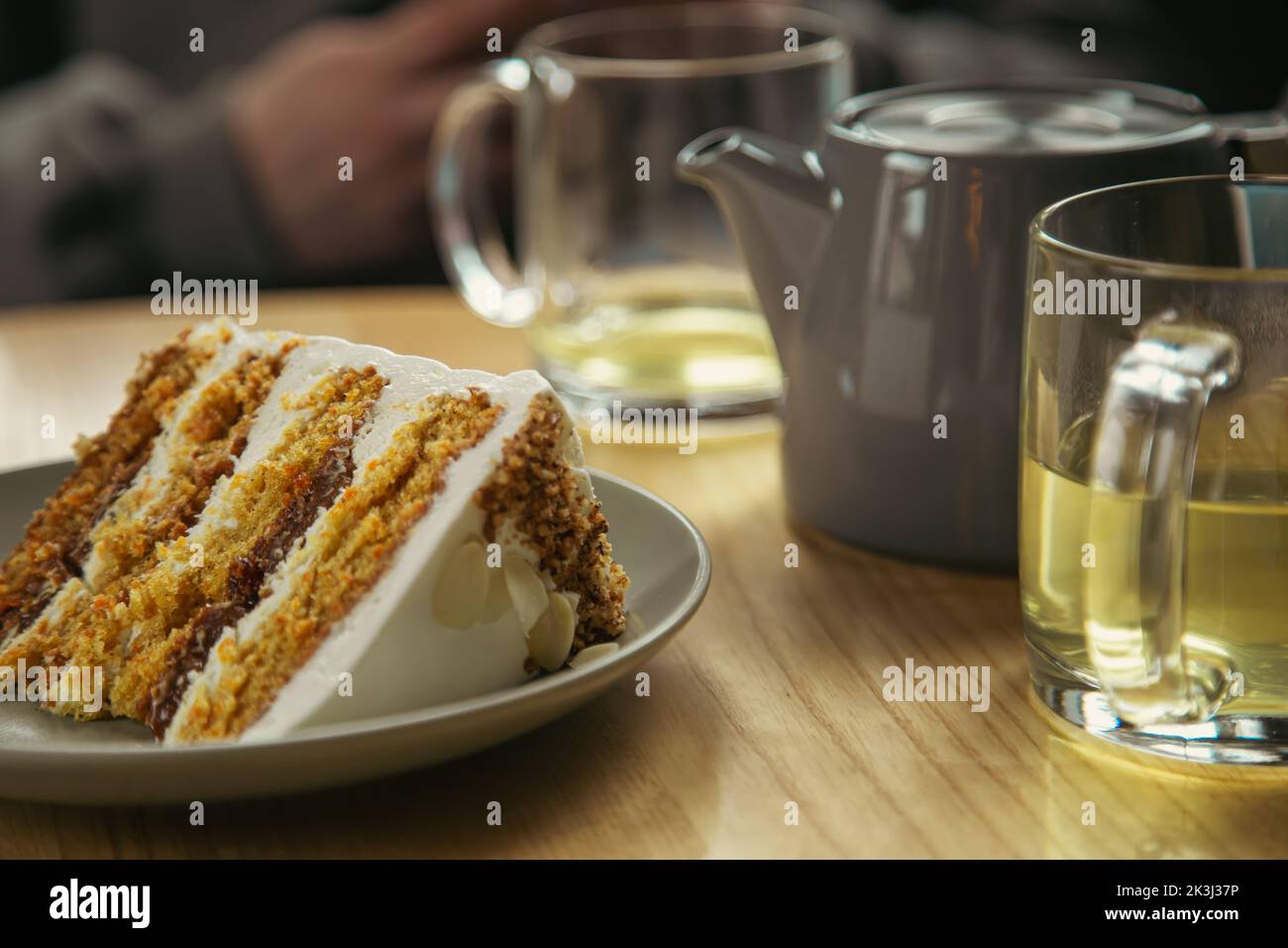 Ein Stück Kuchen auf einem Teller und eine Tasse Nahaufnahme auf einem Tisch in einem Café. Stockfoto