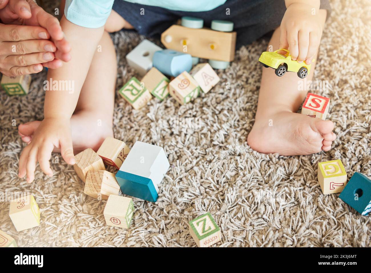 Nahaufnahme des Baby-Lernens mit Spielzeug, Puzzle blockieren und trainieren, um die Koordination der Hand-Augen auf dem Boden zu Hause zu unterstützen. Kleines Kind lernen mit Bildung Spiele auf Stockfoto