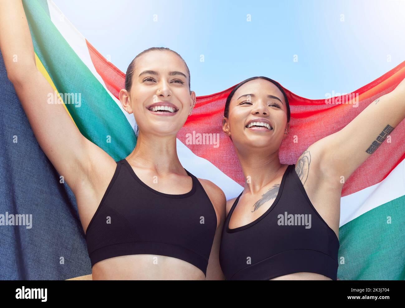 Frauen, Südafrika und Flagge, Gewinnerin bei Sportveranstaltungen oder beim Laufen im globalen Wettbewerb. Lächeln, glücklich und Mädchen zeigen Mannschaftsvielfalt in Feier nach Stockfoto