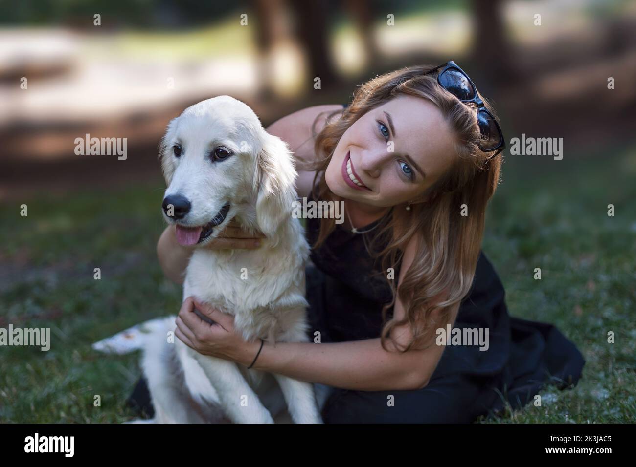 Junge Frauen mit einem fröhlichen cremefarbenen goldenen Retriever. Stockfoto