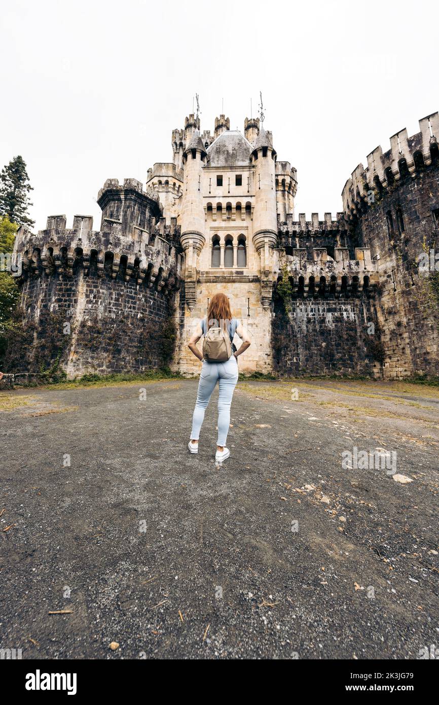 Vertikales Foto einer Frau vor einem Schloss Stockfoto
