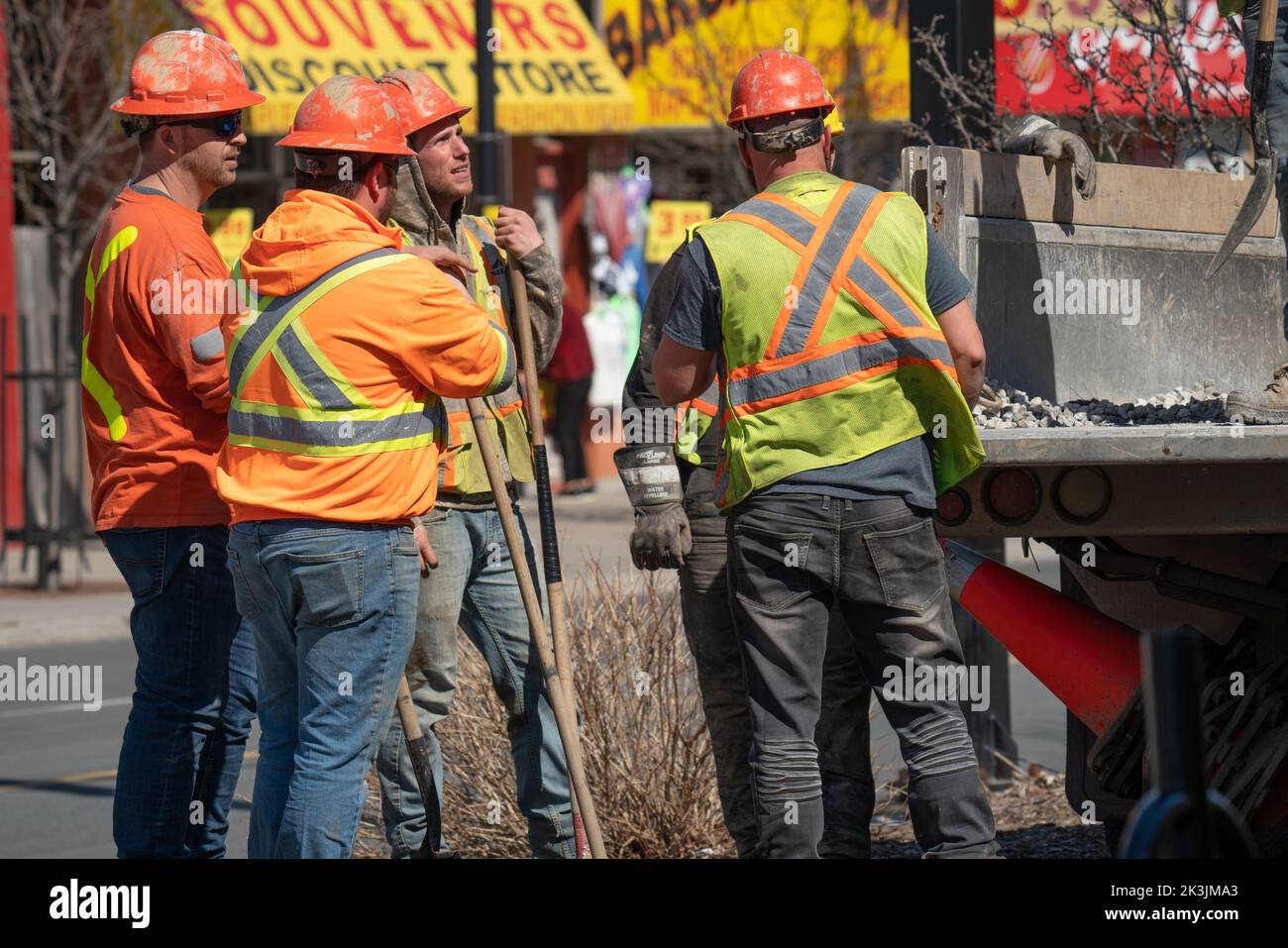 Arbeiter auf einer Baustelle, die Schulungen machen. Drei männliche Mitarbeiter, die 2022 Straßenarbeiten in den Straßen von Toronto, Kanada, machten. Stockfoto
