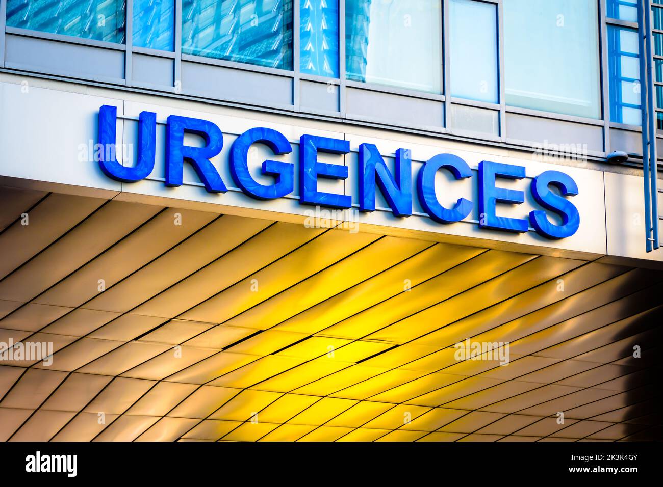 Niedrige Ansicht eines französischen Noteingangszeichens für das Krankenhaus („urgences“ auf französisch) in blauen Großbuchstaben. Stockfoto