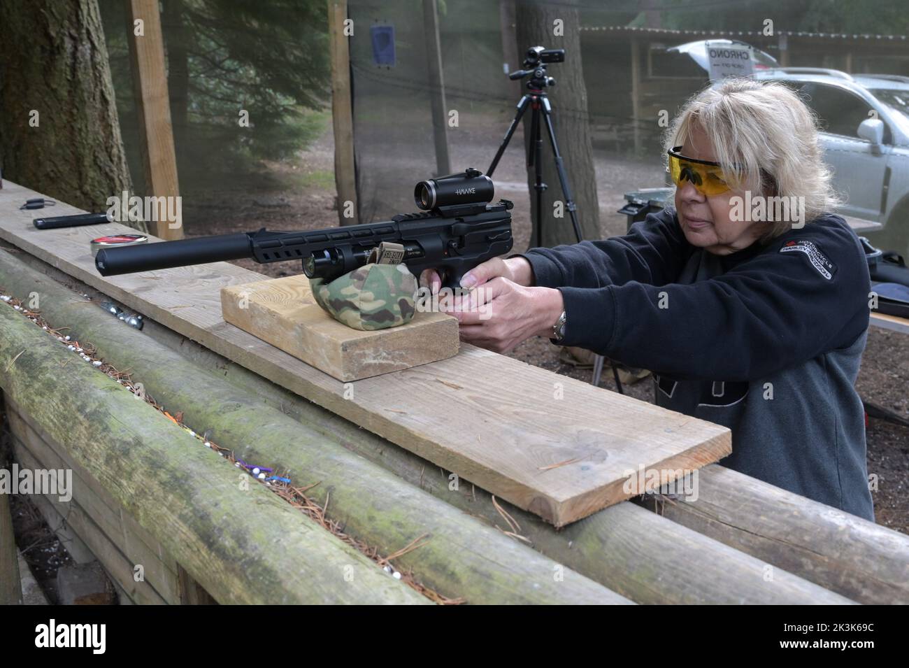 Eine deutsche Luftpistole HW44 pcp, die gerade von einer blonden Dame auf einen Schießstand abgefeuert wird. Stockfoto