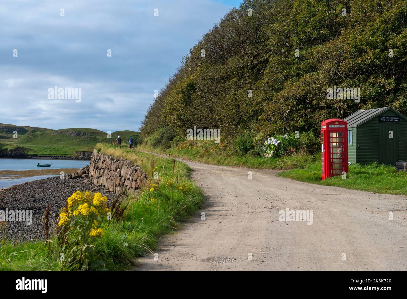 September 2022: Isle of Canna, Inner Hebrides, Schottland das Postamt und die alte rote Telefonbox an der Küstenstraße Stockfoto