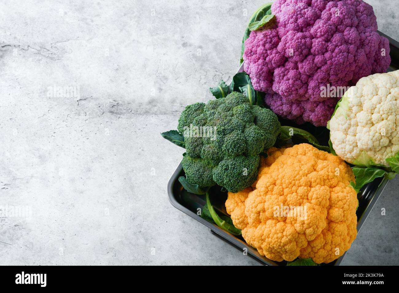 Colorfu-Blumenkohl. Verschiedene Arten von Blumenkohl auf grauem Beton Hintergrund. Violette, gelbe, weiße und grüne Farbkabbage. Brokkoli und Romanesco. Stockfoto