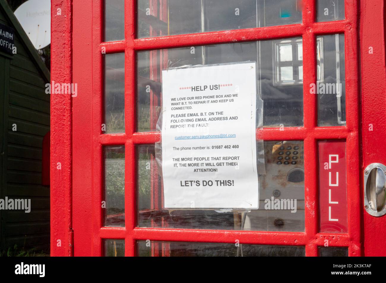 September 2022: Isle of Canna, Inner Hebrides, Schottland die alte rote Telefondose auf der Straße entlang der Küste Stockfoto