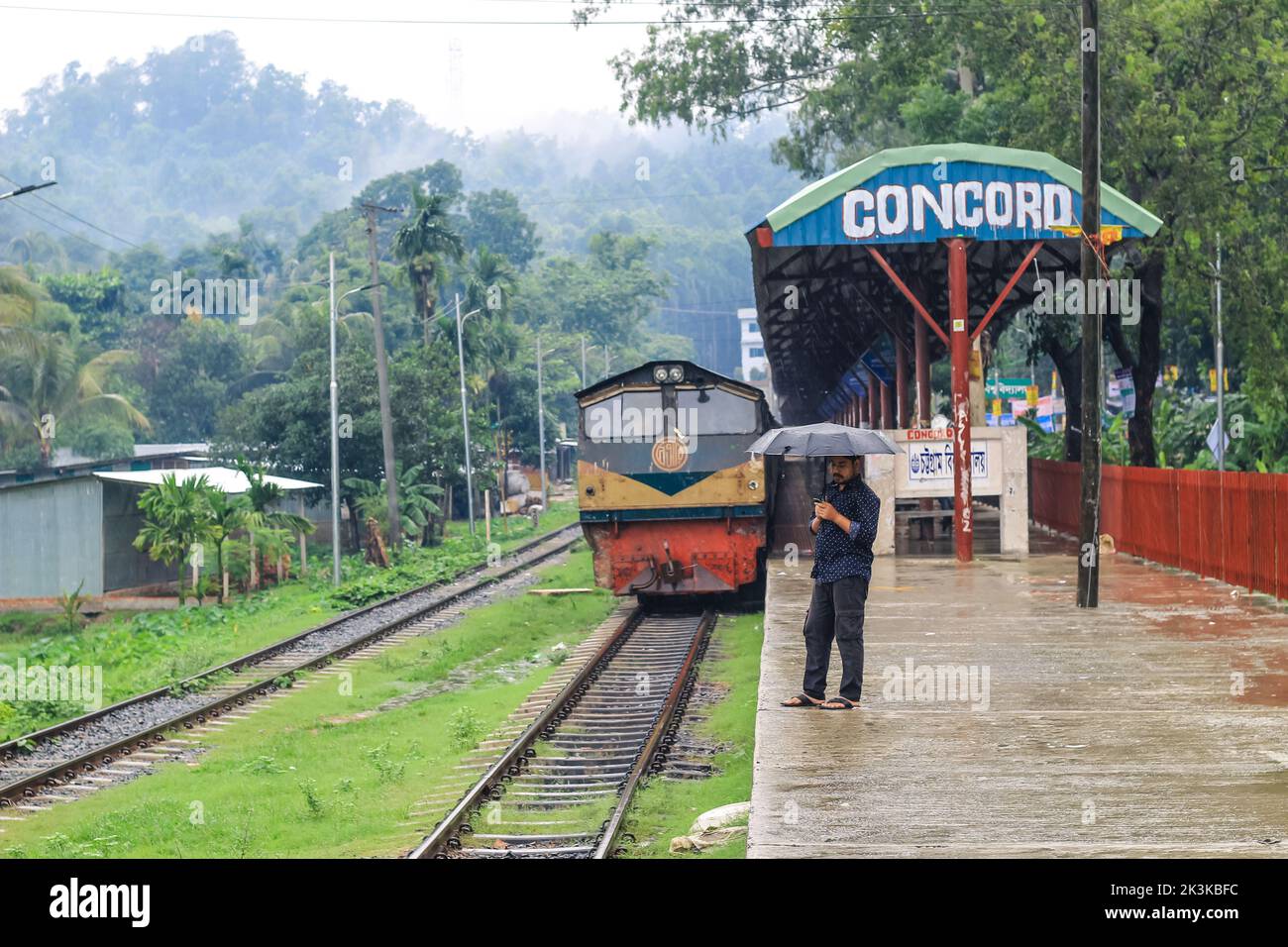 Die Leute warten im Regen auf den Zug. Es ist ein verregneter Bahnhof. University of Chittagong, Bangladesh Railway Station. Stockfoto