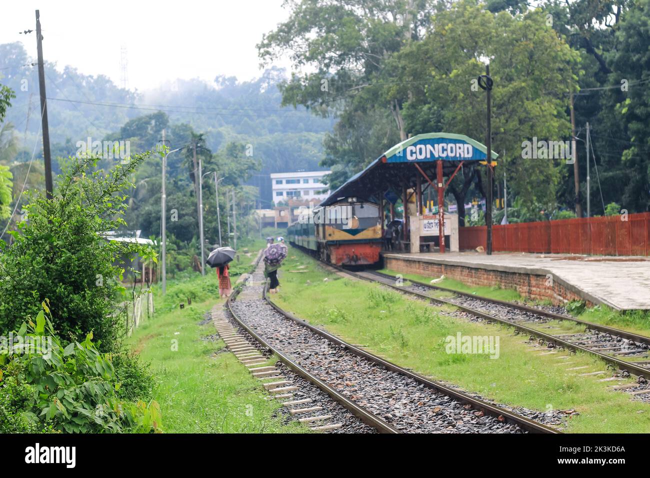 Die Leute warten im Regen auf den Zug. Es ist ein verregneter Bahnhof. University of Chittagong, Bangladesh Railway Station. Stockfoto