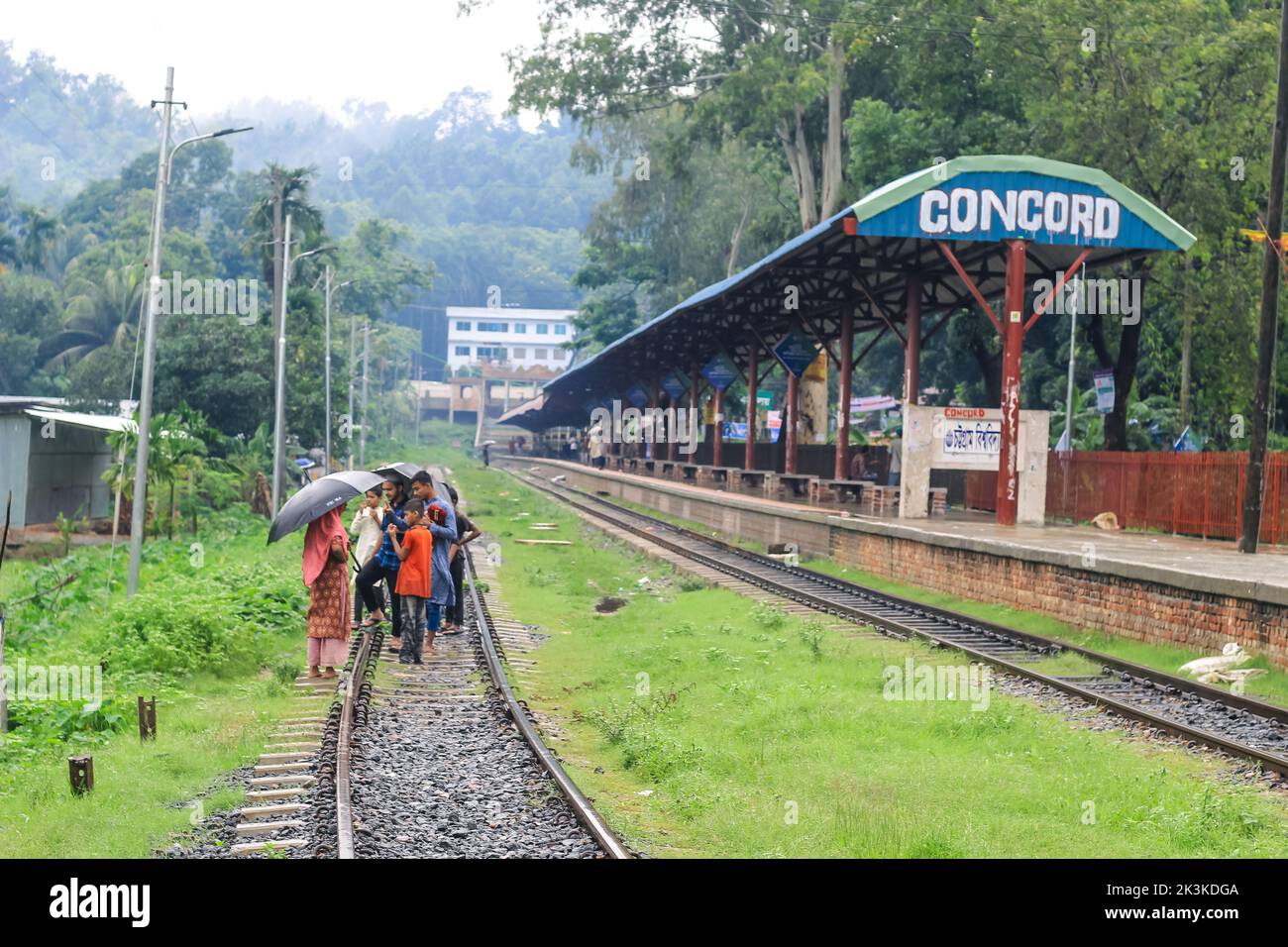 Die Leute warten im Regen auf den Zug. Es ist ein verregneter Bahnhof. University of Chittagong, Bangladesh Railway Station. Stockfoto