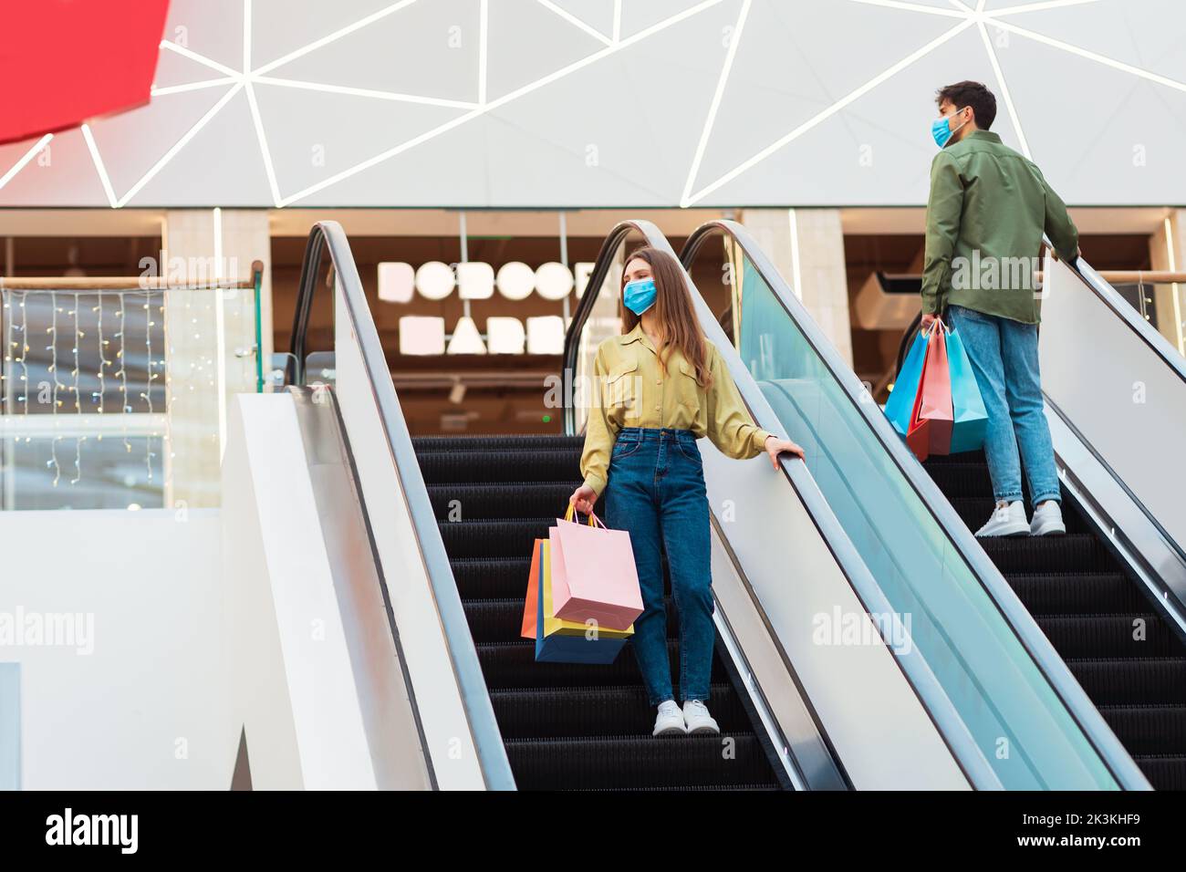 Weibliche Und Männliche Käufer Einkaufen Stehen Auf Treppen In Der Mall Stockfoto