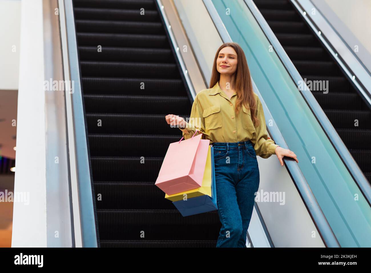 Lady Hält Einkaufstaschen Auf Beweglichen Treppen In Der Mall Stockfoto