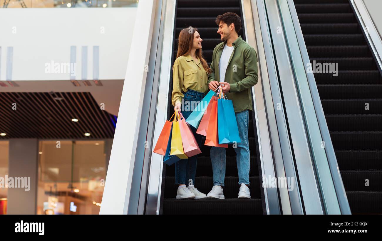 Paar Shopping Holding Bags Stehen Auf Beweglichen Treppen In Der Mall Stockfoto