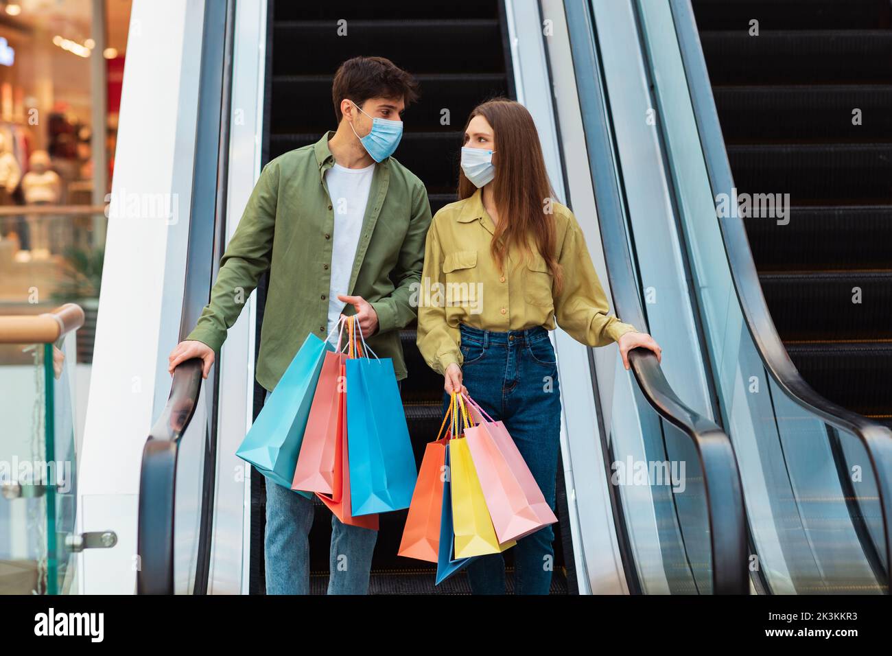 Paar Shopping Holding Bags Stehen Auf Beweglichen Treppen In Der Mall Stockfoto