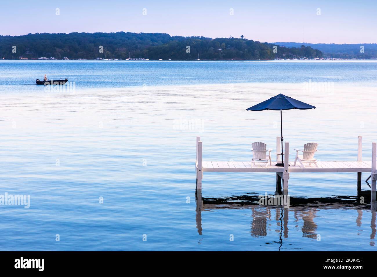 Hölzerner Pier mit Liegestühlen und einem Sonnenschirm mit Blick auf den Genfer See, in der Nähe von Fontana, Wisconsin, Amerika Stockfoto