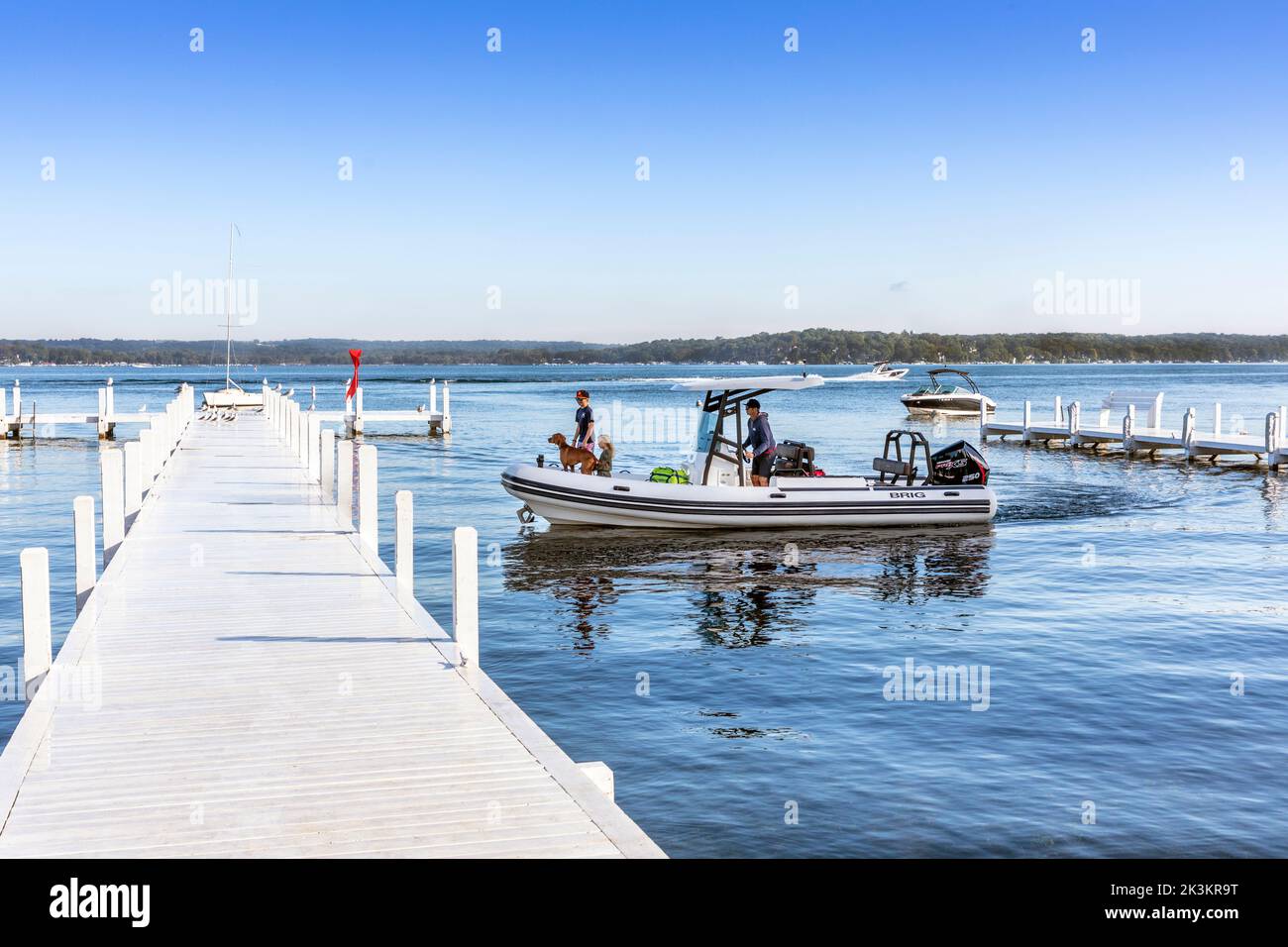 Kleines Schlauchboot, das an einem weißen Holzpier in der Nähe von Fontana, Lake Geneva, Wisconsin, Amerika, ankommt. Stockfoto