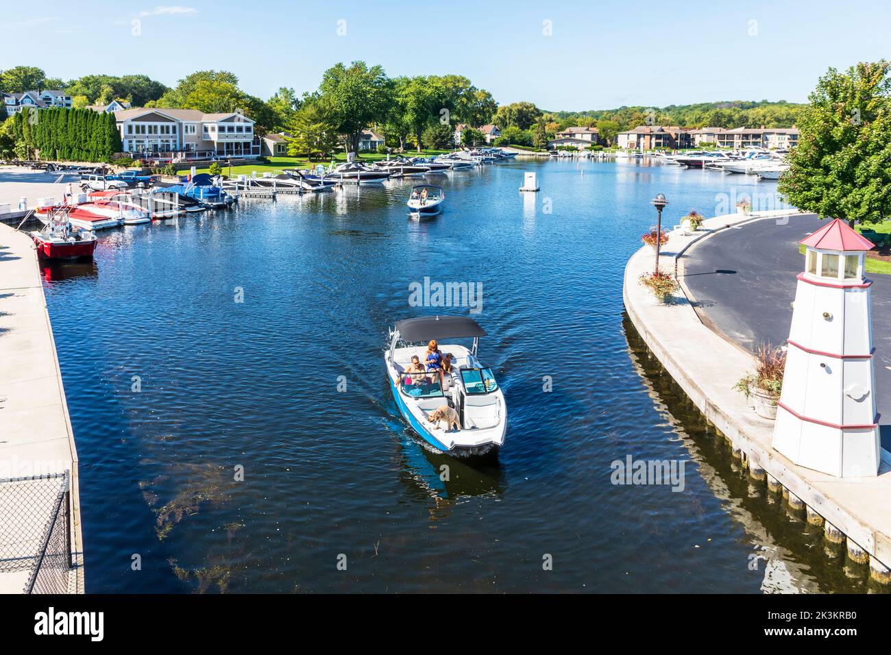 Kleines Boot, das den abgeschiedenen Hafen von Fontana, den Genfersee, Wisconsin, verlässt Stockfoto