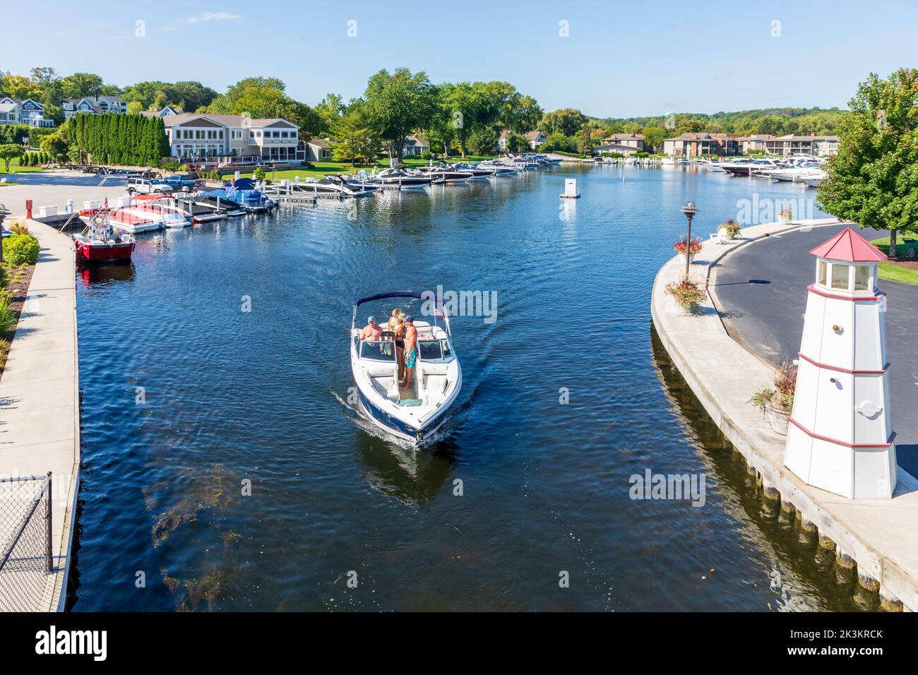 Kleines Boot, das den abgeschiedenen Hafen von Fontana, den Genfersee, Wisconsin, verlässt Stockfoto