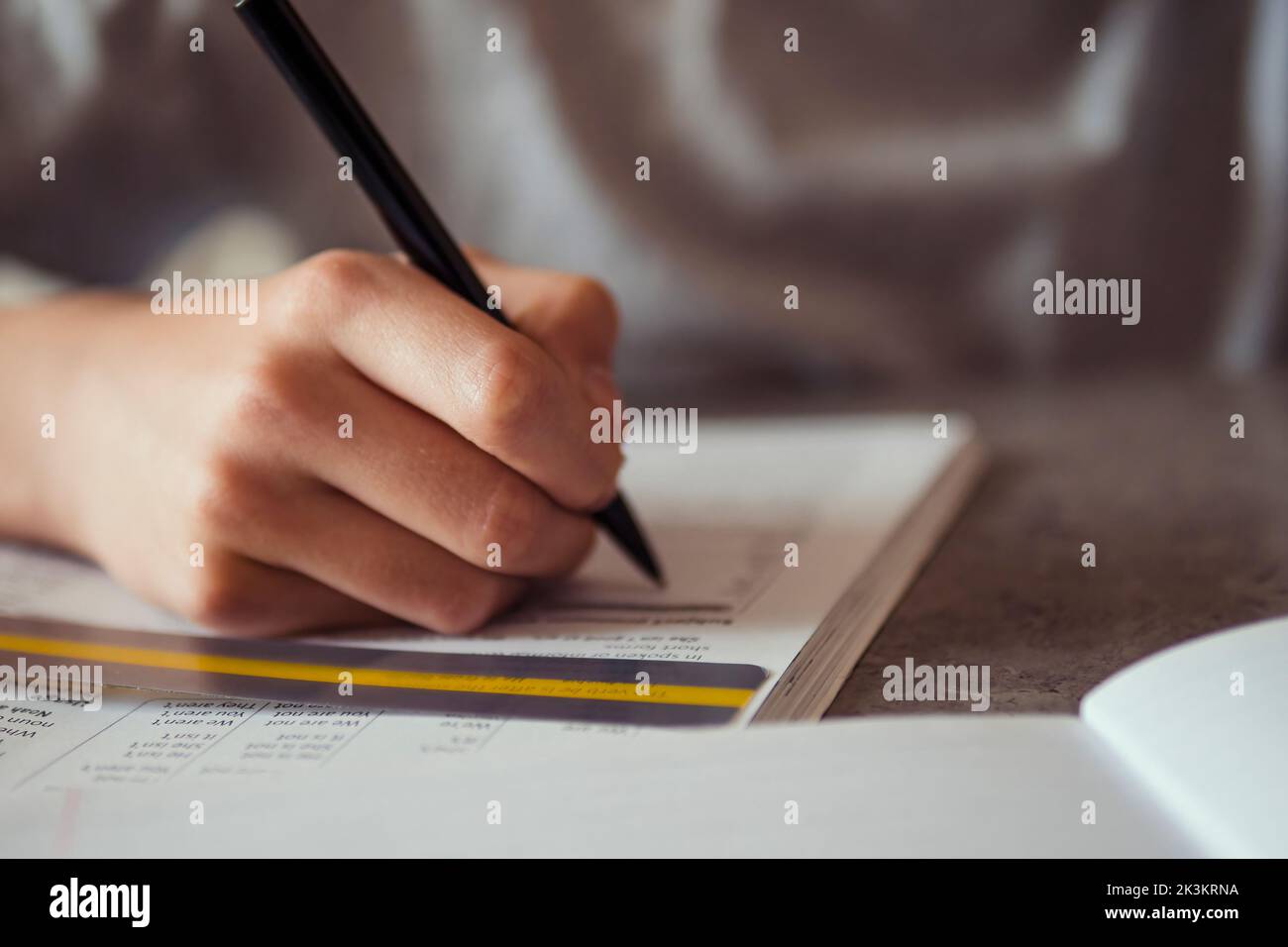 Kind von Legasthenie betroffen Hausaufgaben machen, schreiben, lesen Notebook-Aufgabe mit bunten Overlay-Streifen. Bildung, Lernbehinderung, Lesen Stockfoto