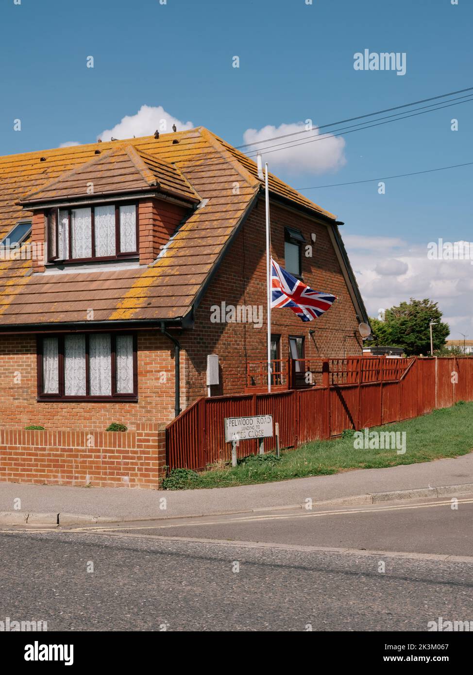 Eine britische Unionsflagge fliegt am halben Mast in Trauer um die Passierung der Königin in einer Wohnsiedlung in einem Vorort Lydd, Sussex, England, Großbritannien - September 2022 Stockfoto