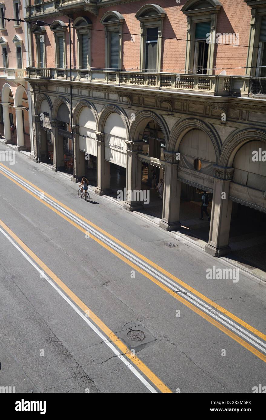 Porticoes entlang der Via dell'Indipendenza mit einsamen Radfahrern und ohne Autos in Bologna Emilia Romagna Italien Stockfoto