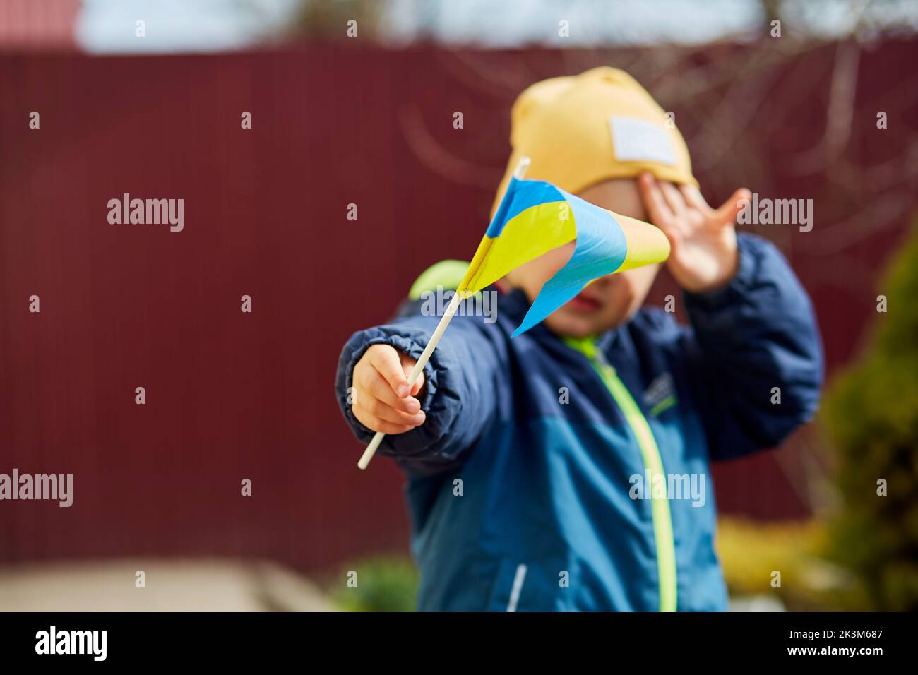 Patriotischer kleiner Junge hält ukrainische Flagge. Stehe mit der Ukraine. Unterstützt Die Ukraine. Stoppt das russische Angriffskonzept. Beenden Sie den Krieg in der Ukraine. Betet für die Ukraine Stockfoto