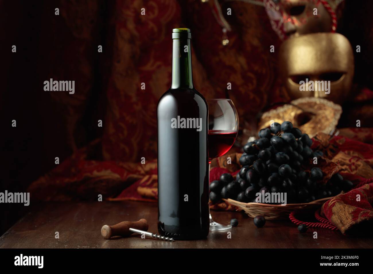 Stillleben mit Rotwein, Trauben und Jahrgangsmasken. Stockfoto