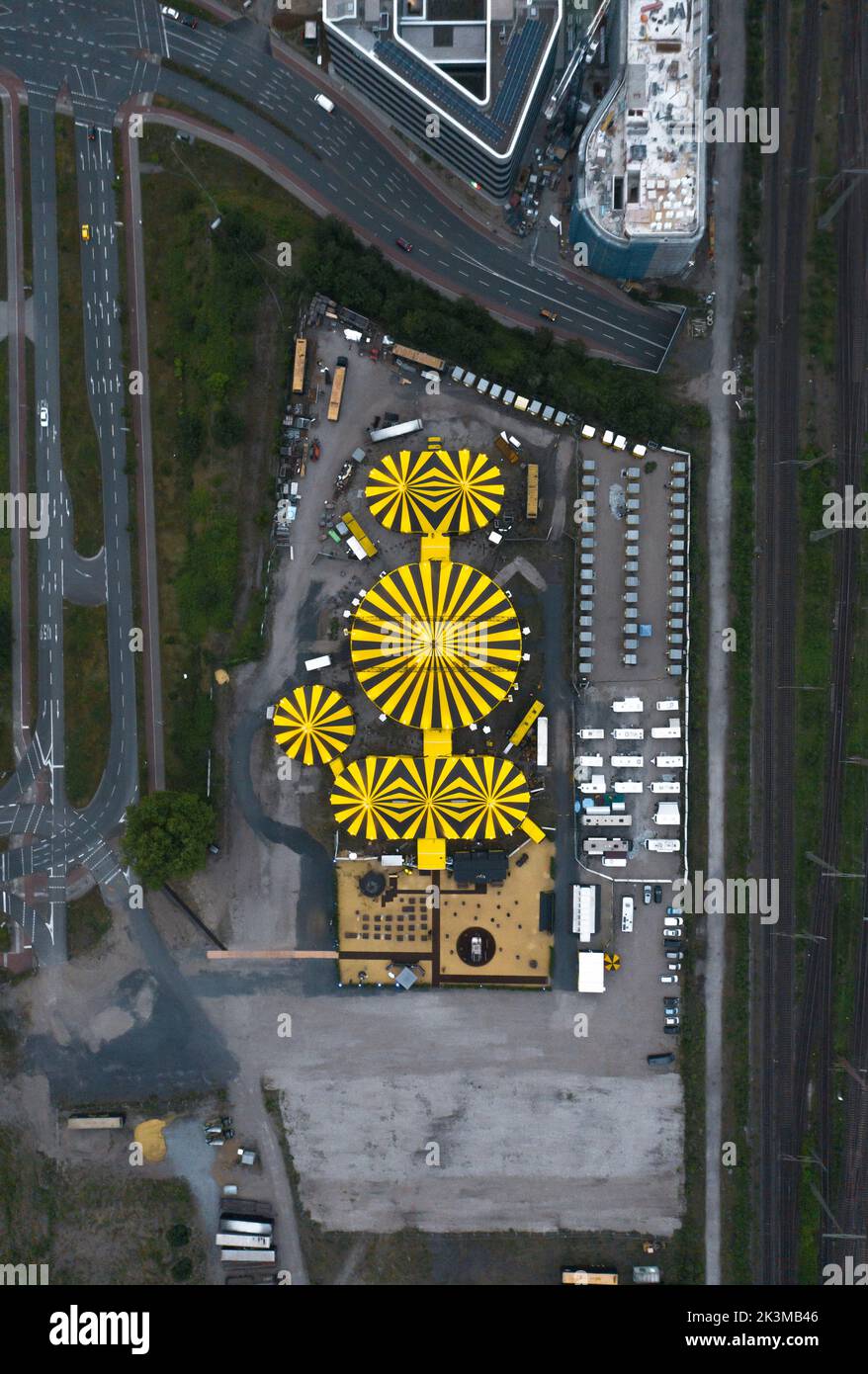 Draufsicht auf das Stadtbild mit modernen Gebäuden und Zirkuszelten, die an sonnigen Tagen in Deutschland in Straßennähe aufgestellt wurden Stockfoto