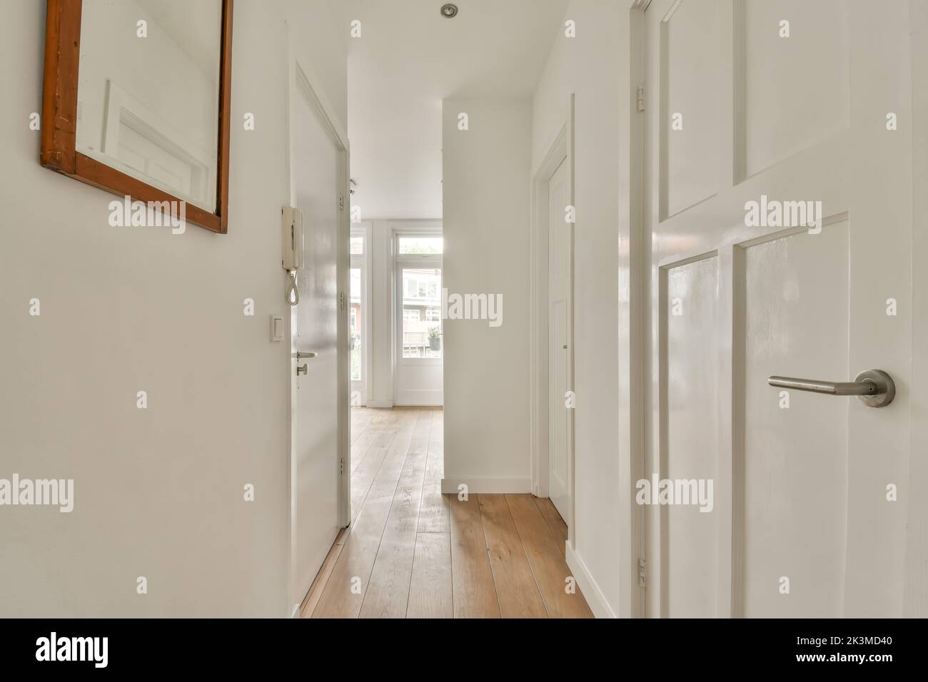 Innen Flur mit geschlossenen weißen Zimmertüren und Parkett in Licht stilvolle moderne Wohnung mit glühender Beleuchtung zu Hause Stockfoto
