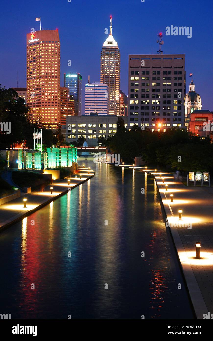 Die Skyline von Indianapolis wird nachts beleuchtet und spiegelt sich im Wasser des Canal Walk der Stadt wider Stockfoto