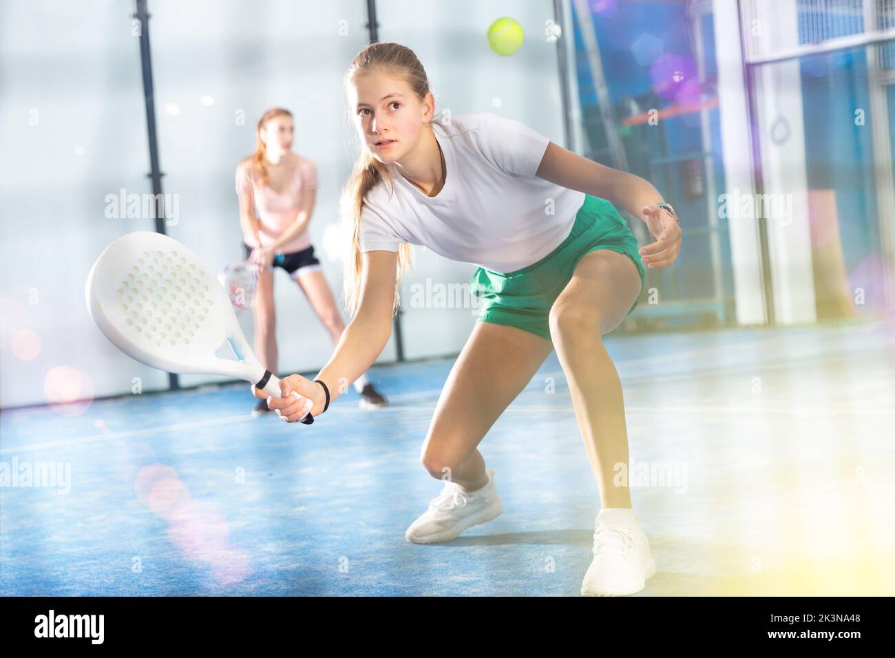 Aktives Teenager-Mädchen, das Padel auf dem Tennisplatz spielt Stockfoto