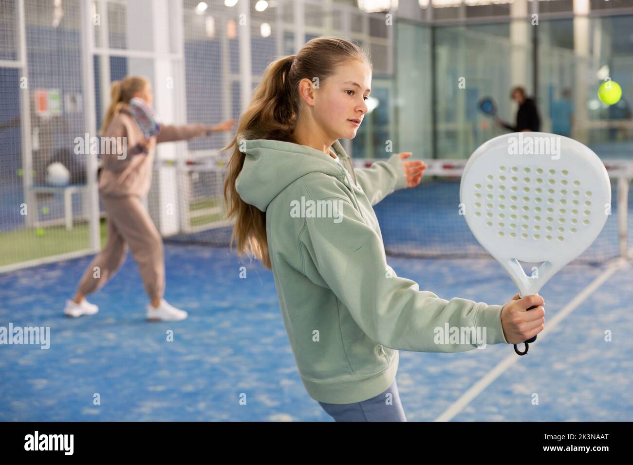 Aktives Teenager-Mädchen, das Padel auf dem Tennisplatz spielt Stockfoto