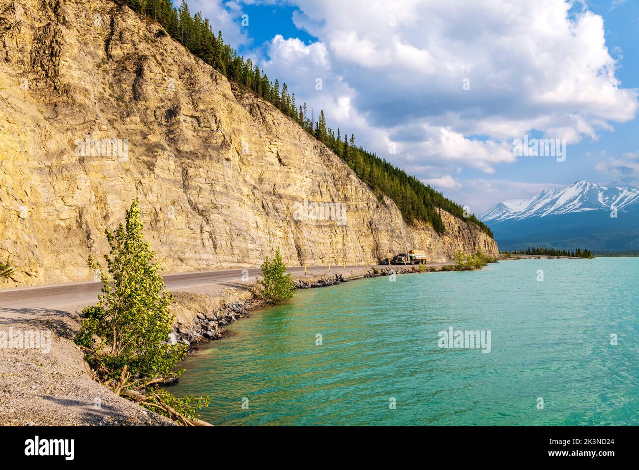 Traktoranhänger fährt auf dem Alaska Highway entlang des Muncho Lake, umgeben von den kanadischen Rocky Mountains, British Columbia und Kanada Stockfoto