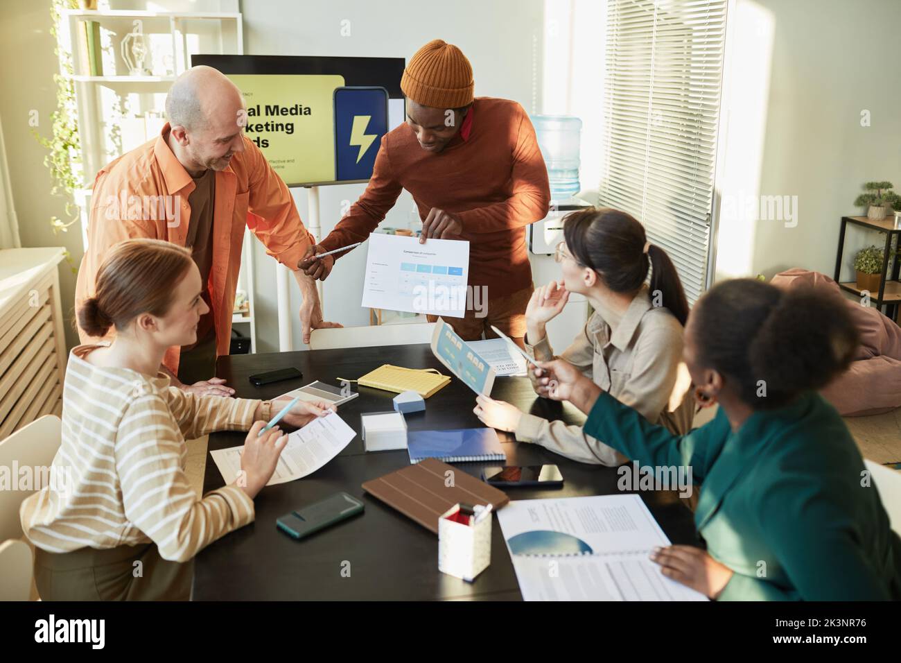 Porträt eines kreativen Geschäftsteams, das sich im Büro trifft, wobei der Schwerpunkt auf schwarzen Männern liegt, die Marketingdaten präsentieren Stockfoto