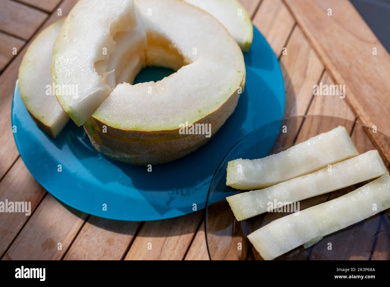 Nahaufnahme in Scheiben geschnittene reife Melone auf dem Holztisch, Sonnentag im Freien Stockfoto