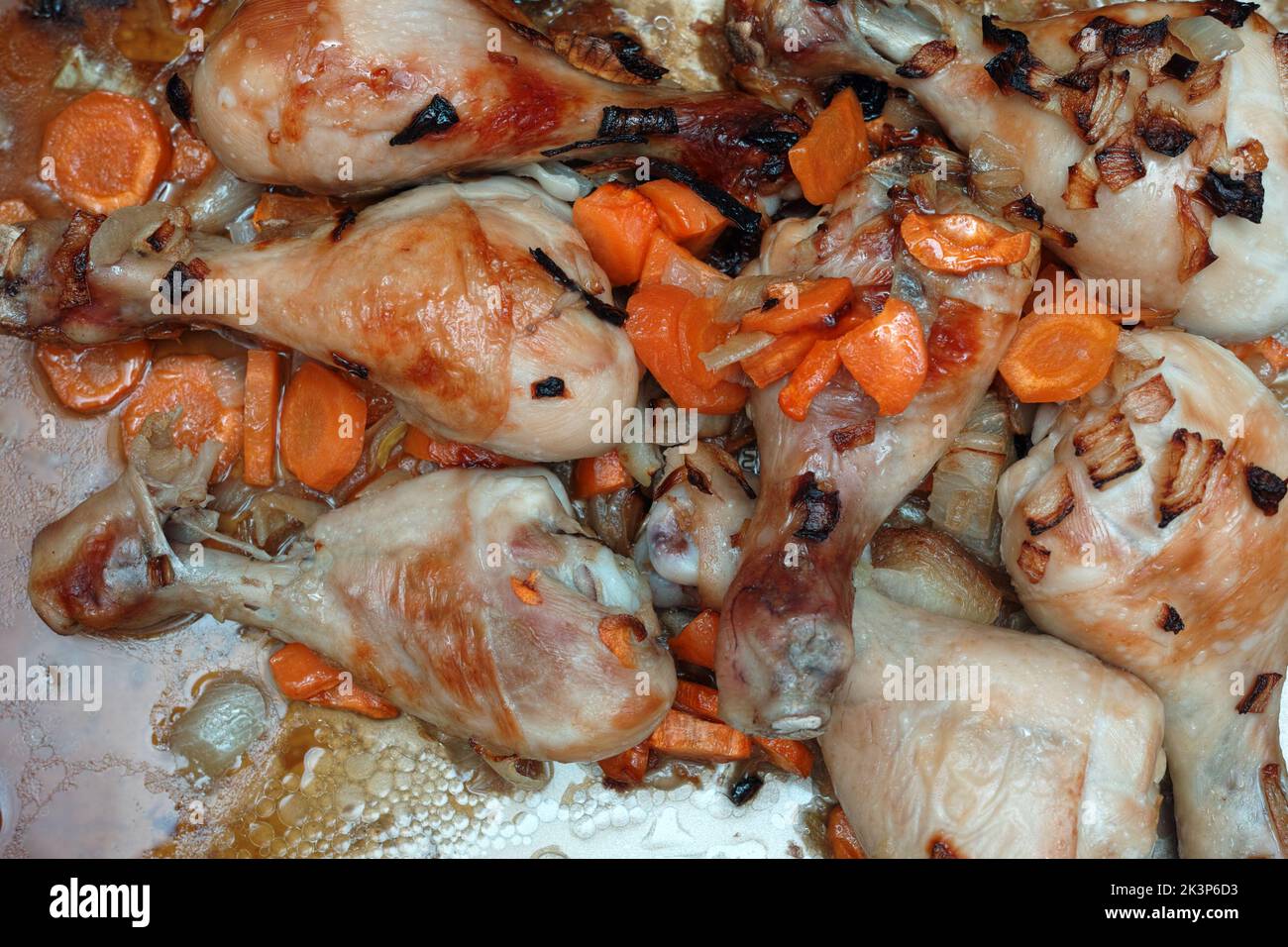 Hähnchendrumsticks mit Zwiebeln und Karotten, Nahaufnahme des Studios Stockfoto