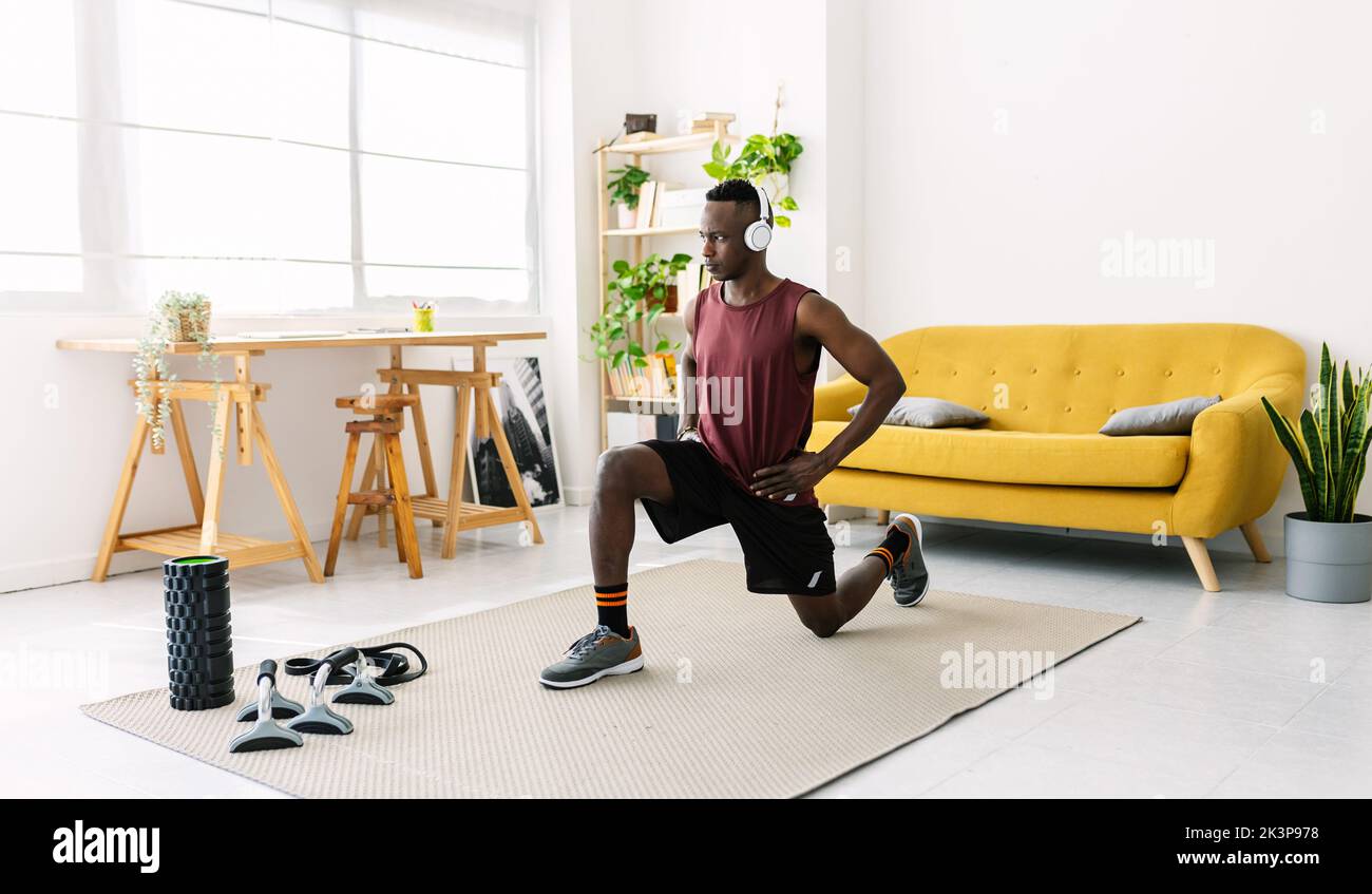 Junger afrikanischer Mann, der zu Hause Fitness trainiert Stockfoto