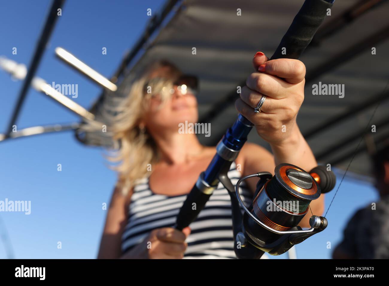 Nahaufnahme einer Frau, die mit Angelrute im Meer fischt Stockfoto