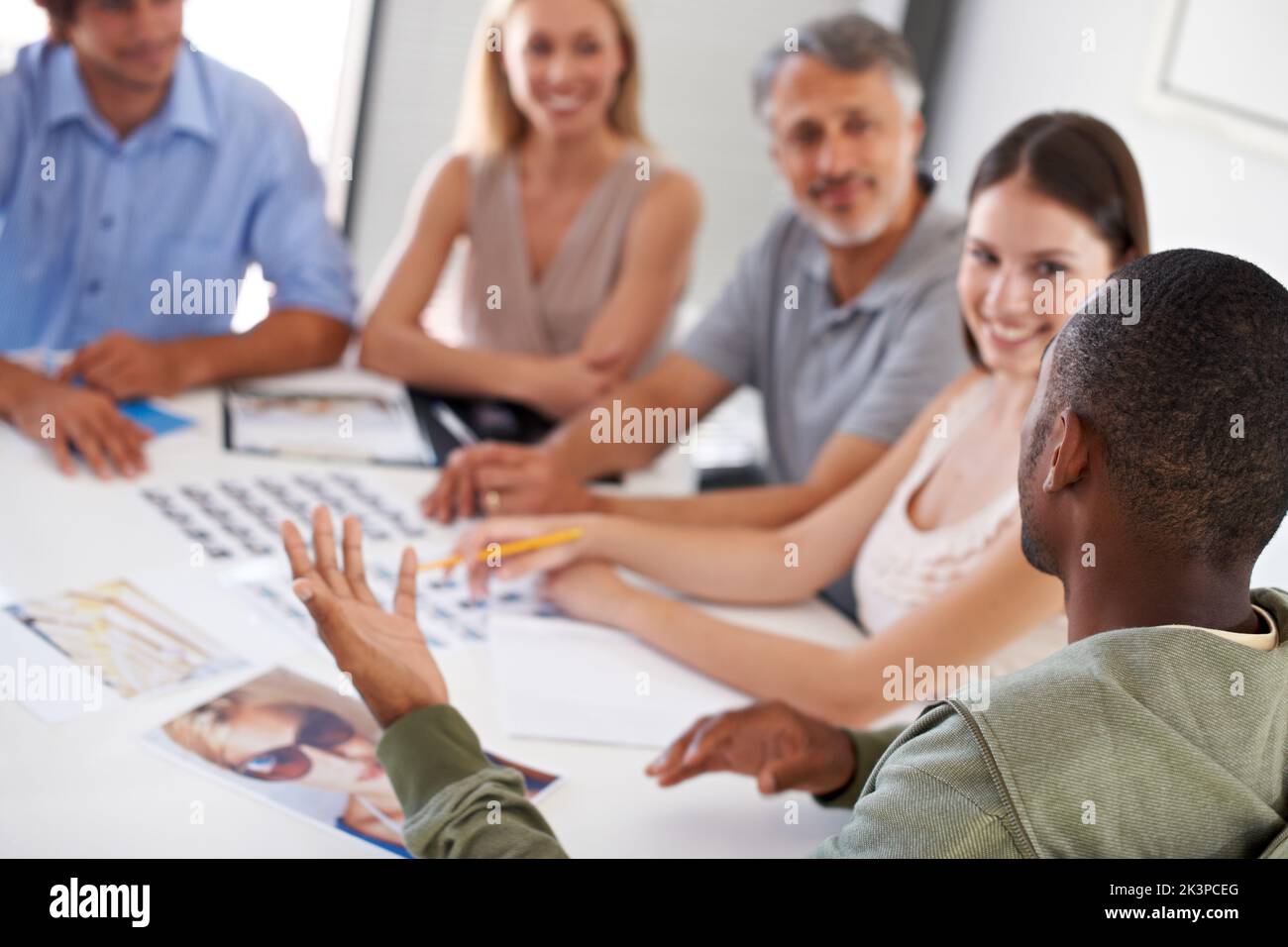 In Diskussion. Eine Gruppe von Geschäftsleuten, die Modelle für eine Werbekampagne auswählen, an der sie arbeiten. Stockfoto