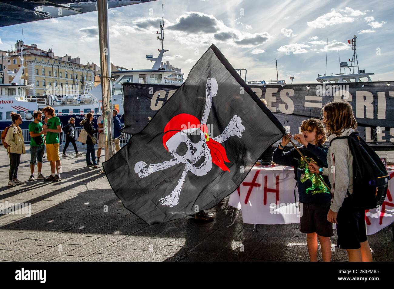 Marseille, Frankreich. 27. September 2022. Demonstranten halten während der Demonstration eine Piratenfahne mit einem Schädel und Kreuzknochen. Anti-Kreuzfahrt- und nachhaltige Tourismusaktivisten demonstrieren im Schatten des Alten Hafens und prangern die Belästigung und Verschmutzung der in der Stadt anrufenden Kreuzschiffe an. Kredit: SOPA Images Limited/Alamy Live Nachrichten Stockfoto