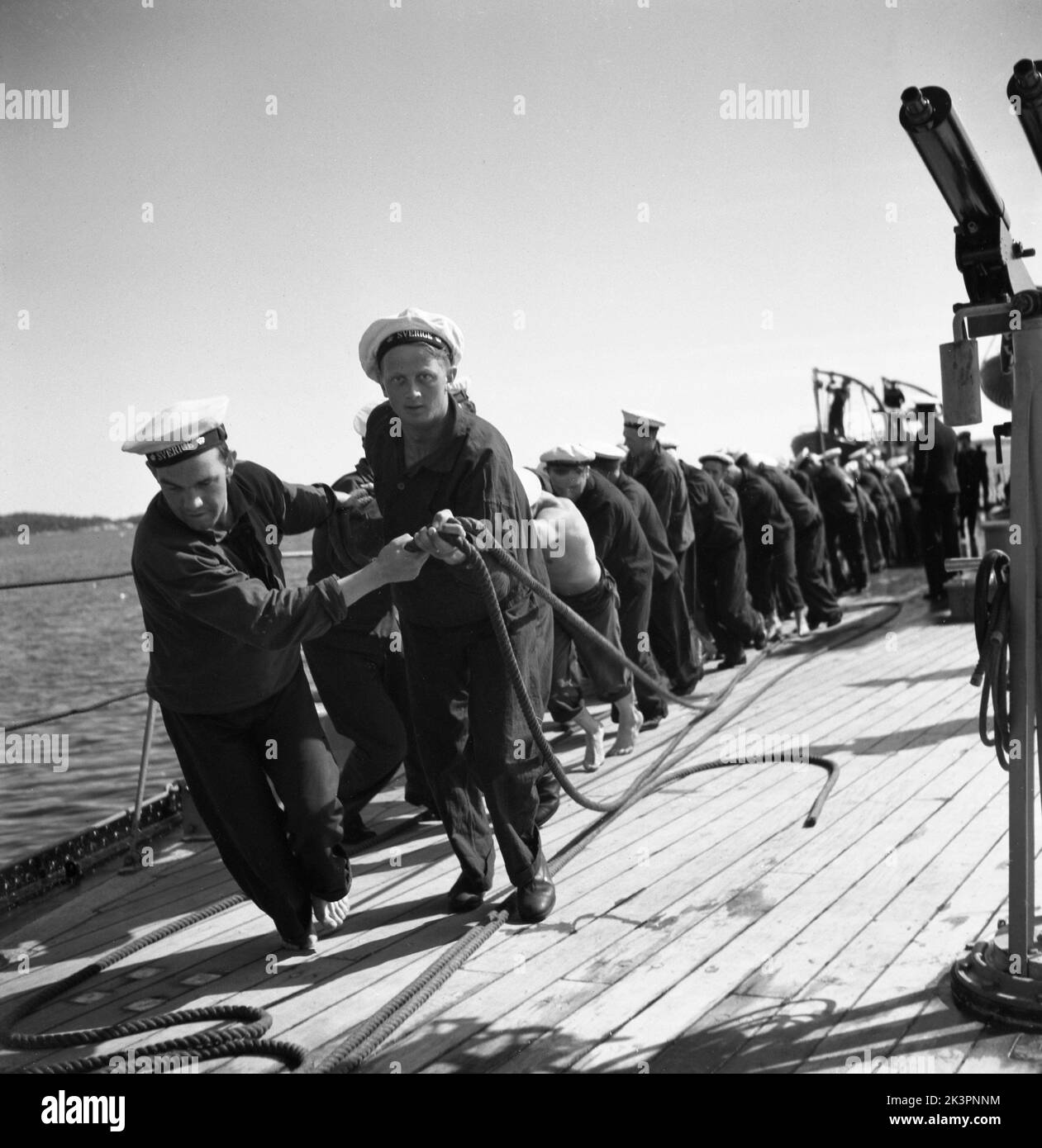 Während des Zweiten Weltkriegs Das Kriegsschiff Sverige während der Marineübungen auf See. Die Matrosen ziehen alle etwas Schweres an Deck, wie eine Ankerlinie. Schweden juni 1940. Kristoffersson Ref. 141 Stockfoto