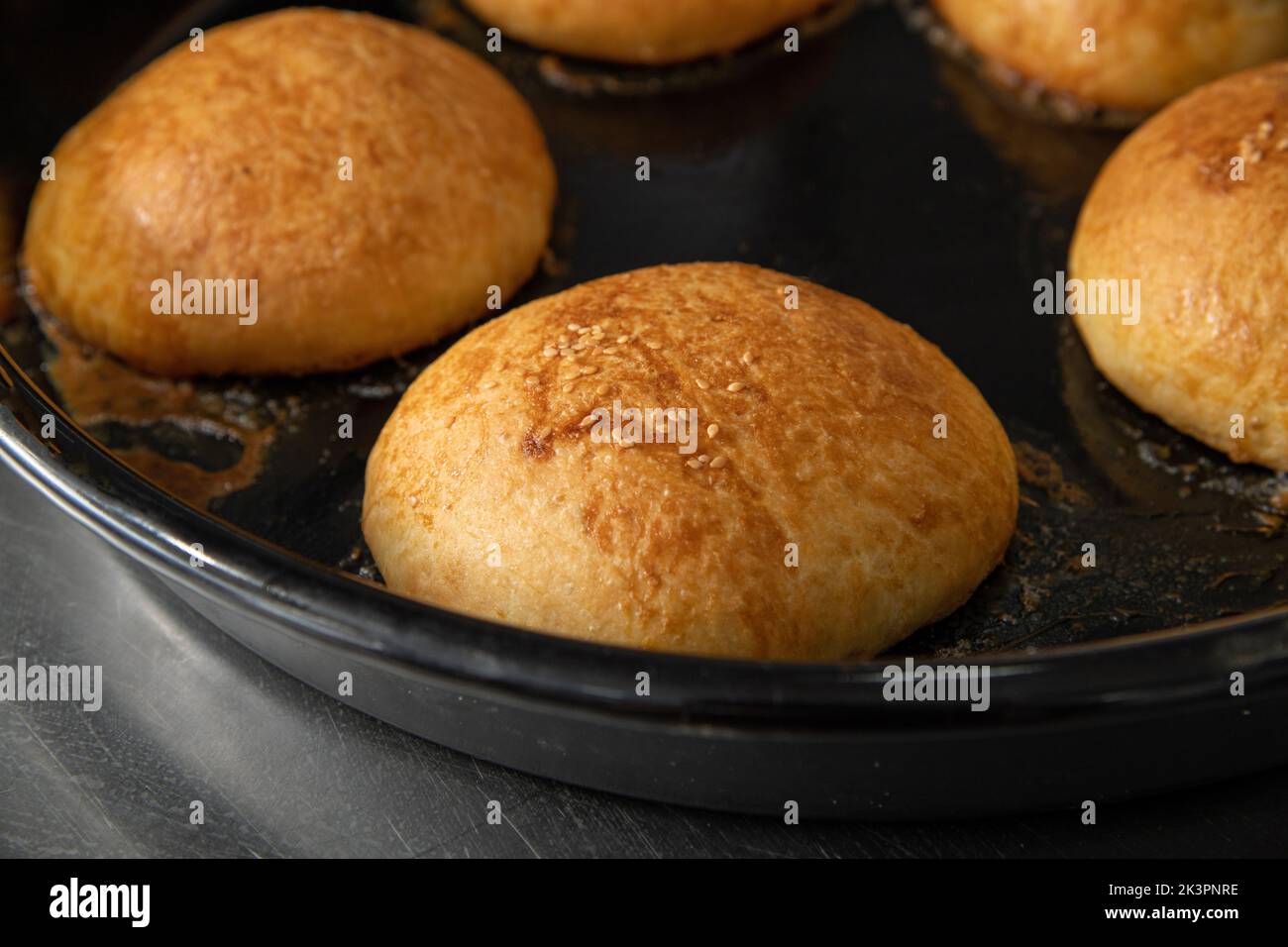 Frisch gebackene heiße Burger-Brötchen in einem Industrieofen Stockfoto