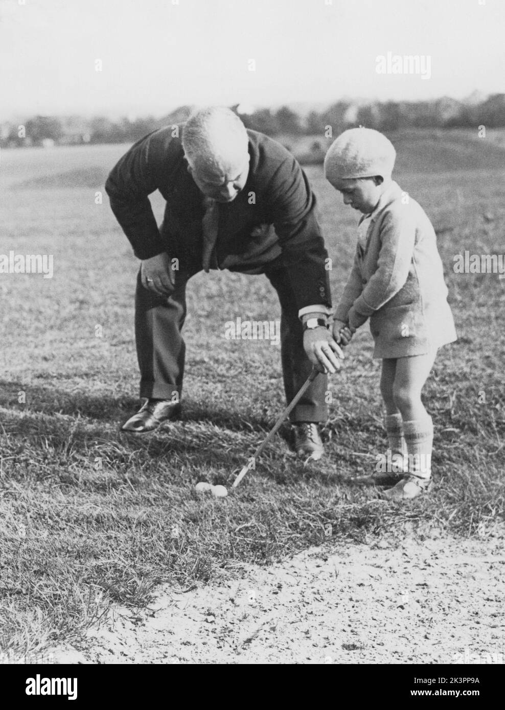 Golf in der 1930s. Eine niedliche Szene auf dem Woodcote Course, wo der fünfjährige Derick Paine von seinem Vater einige Ratschläge erhalten hat, wie er den Golfclub halten kann. 28. september 1934. Der Woodcote Park Golf Club wurde 1912 gegründet und befindet sich zwischen and Purley und Coulsdon in Surrey. Stockfoto