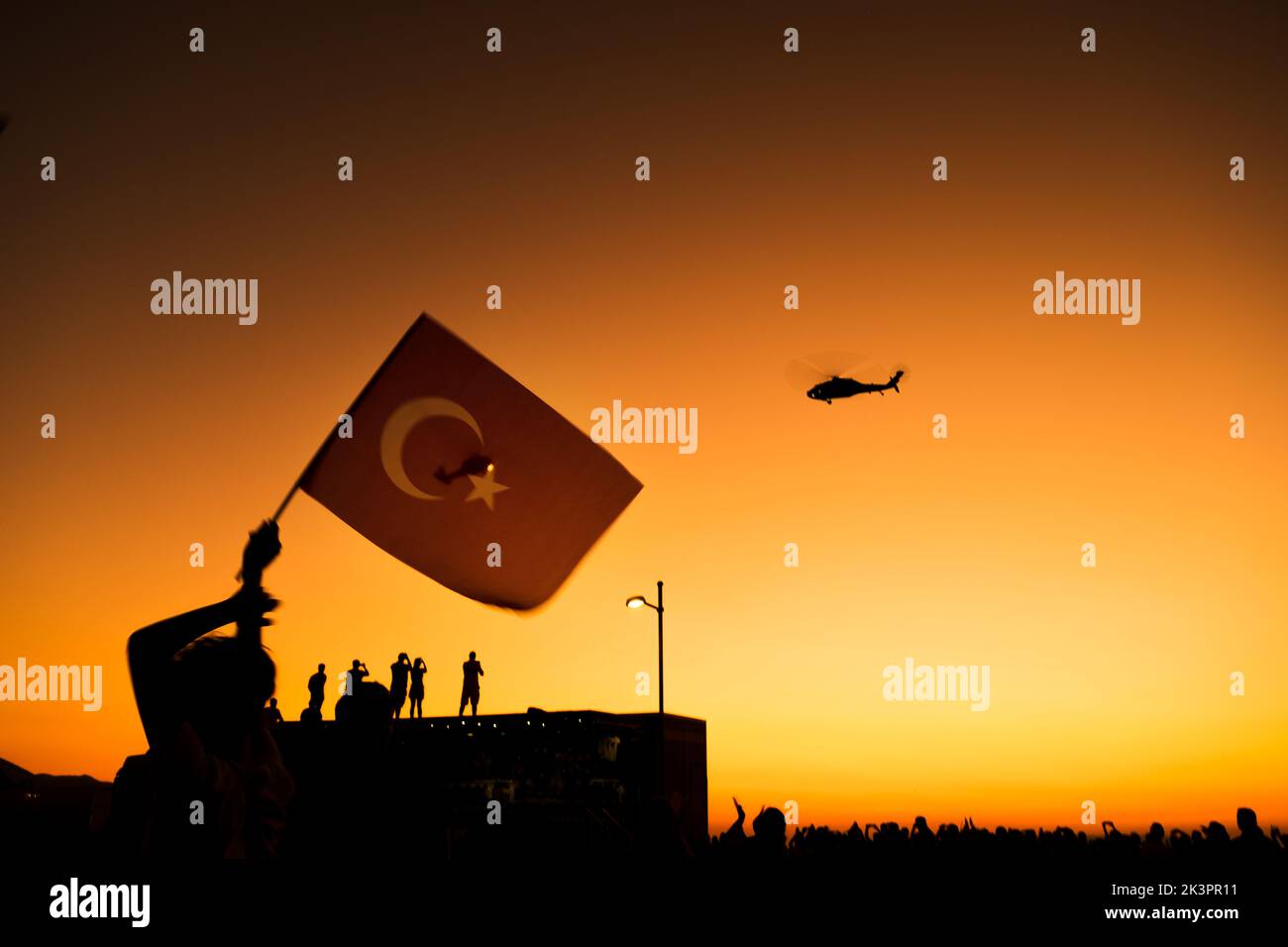 Izmir, Türkei - 9. September 2022: Nahaufnahme einer türkischen Flagge in den überfüllten Menschen mit Gendarm-Hubschraubern am Himmel am Tag der Freiheit von I Stockfoto