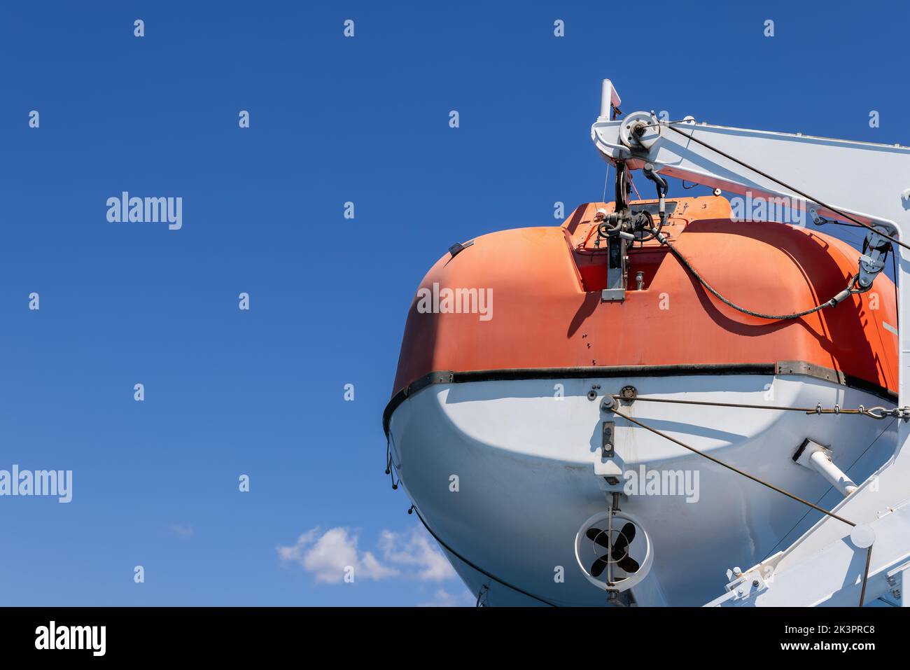 Orangefarbenes Rettungsmotorboot, mit dem jede Passagierfähre ausgestattet ist, Hintergrund mit klarem blauen Sommermorgendhimmel Stockfoto