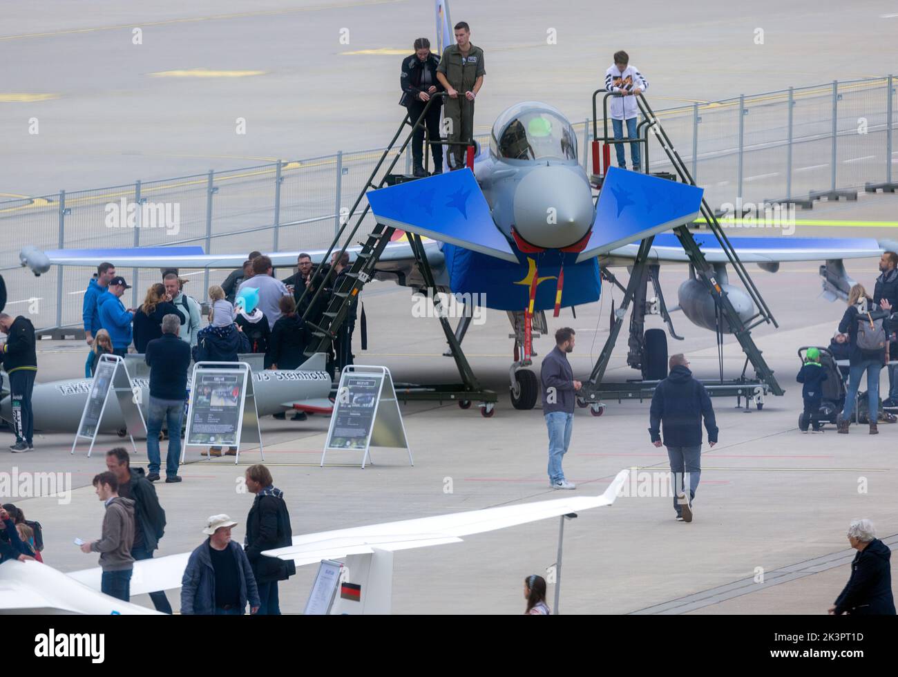 Laage, Deutschland. 24. September 2022. Auf dem Flughafenfest werfen junge und alte Besucher einen Blick in das Cockpit eines Eurofighters, das anlässlich des 25.-jährigen Jubiläums der Jagdgeschwader in einer speziellen Farbgebung gestrichen wurde. Mehr als 10.000 Menschen nahmen am Flughafenfest Teil und konnten damit einen neuen Besucherrekord für das Ereignis nach der Pandemiepause verzeichnen. Der neue Flughafenbetreiber, die Zeitfracht Group, gab einen Einblick in die Pläne des Flughafens rund um die Luftfahrt. Quelle: Jens Büttner/dpa/Alamy Live News Stockfoto